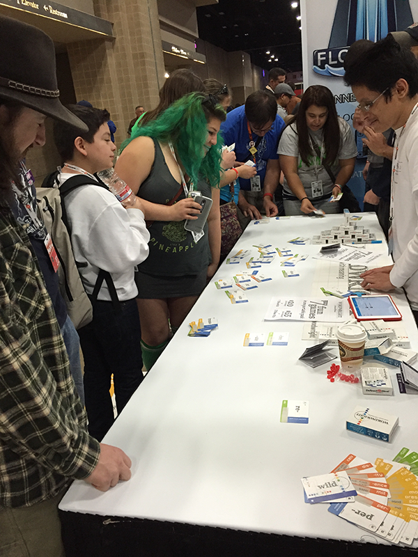 Image shows multiple people engaging with the game at PAX South